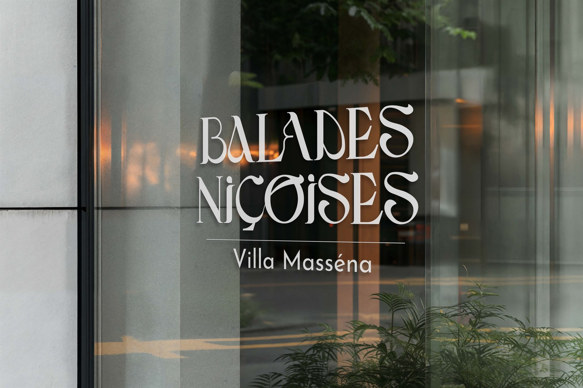 Le logo-titre « Balades Niçoises, Villa Masséna » en blanc sur une vitrine, des reflets de lumière derrière