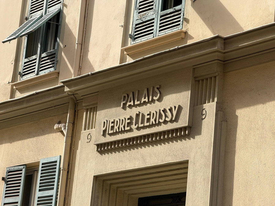 Inscription « Palais Pierre Lerissy » sur une façade ocre, entre deux fenêtres à volets