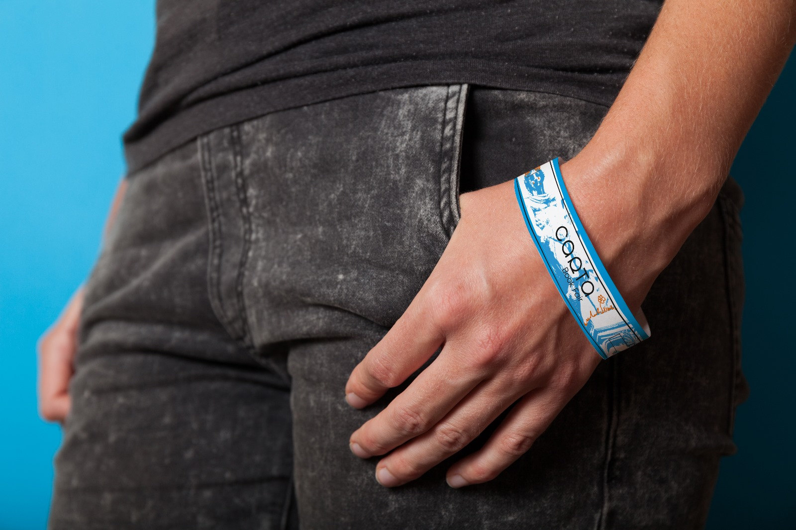 Un bracelet Carta cyan au poignet, sur fond bleu