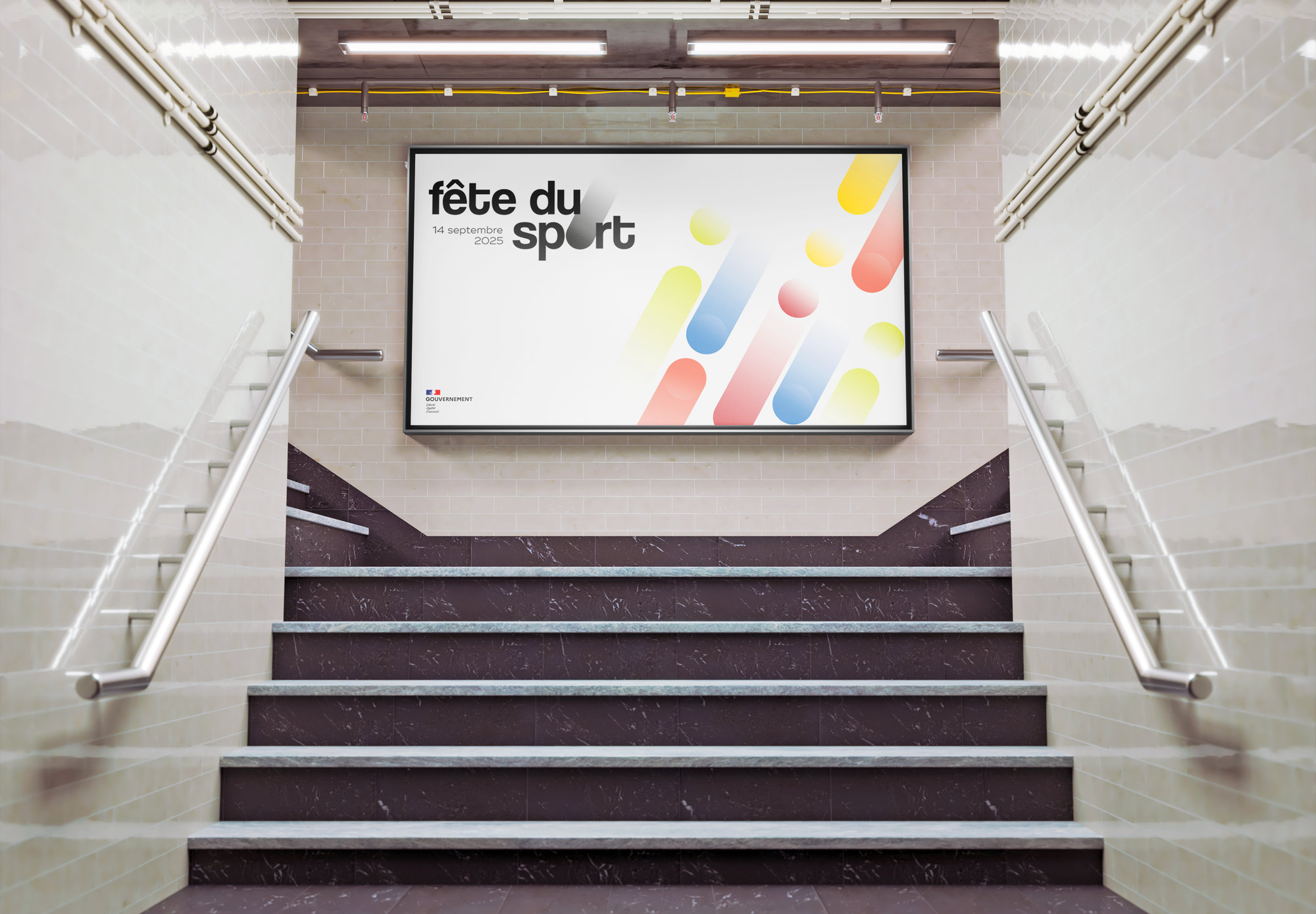 Grand panneau dans une gare, en haut d’un escalier : le logo et des formes arrondies de toutes les couleurs