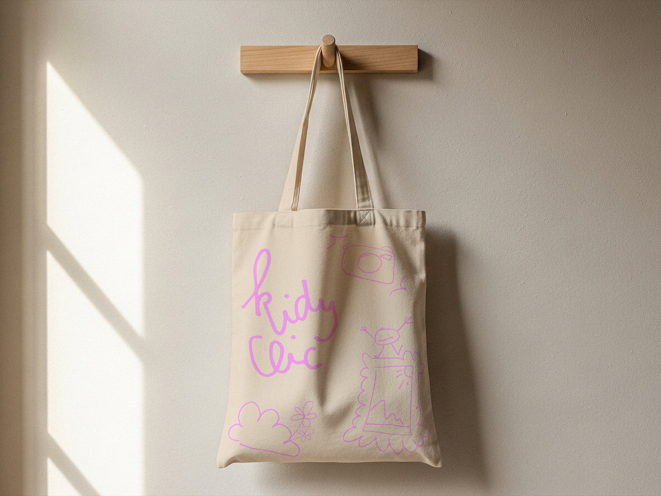 Le même tote bag, le logo et les dessins en rose pâle