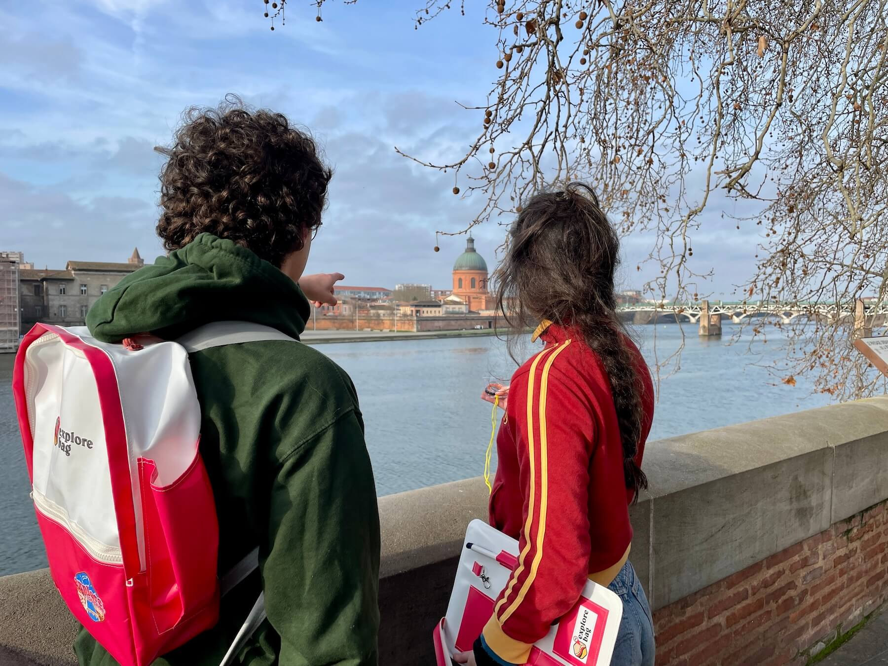 Deux joueurs, sac My Explore Bag sur le dos, face à la Garonne et au dôme de la Grave à Toulouse