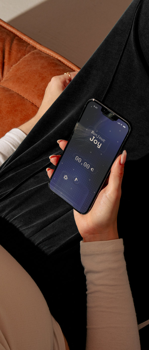Une main tient un téléphone affichant l’accueil de Nova