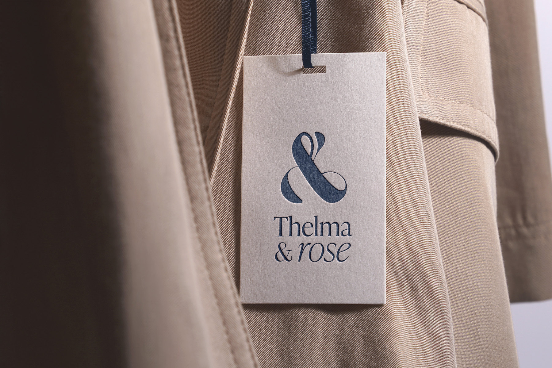 L’étiquette Thelma & Rose, recto, accrochée à un manteau beige